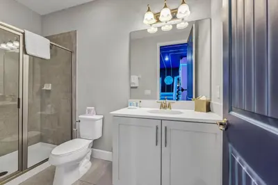 a white bathroom with a toilet and a sink at Fun-Filled Getaway With Private Pool, Theme Rooms & Game Room And Waterpark Access Near Disney At Encore Resorts Reunion - 7604Mc in Orlando