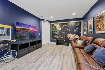 a living room with a couch and a flat screen tv at Fun-Filled Getaway With Private Pool, Theme Rooms & Game Room And Waterpark Access Near Disney At Encore Resorts Reunion - 7604Mc in Orlando