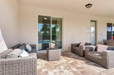 a living room with wicker couches and chairs at Fun-Filled Getaway With Private Pool, Theme Rooms & Game Room And Waterpark Access Near Disney At Encore Resorts Reunion - 7604Mc in Orlando