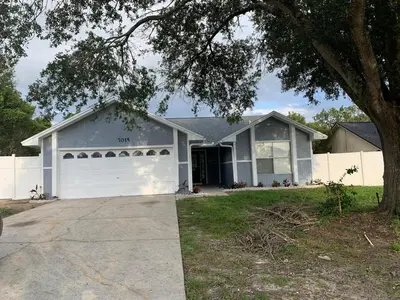 a white house with a white garage at Ortona's Best Kept Secret Three-Two Spacious Home in Orlando