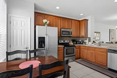 a kitchen with wooden cabinets and a white refrigerator at Casa 3Q Vista Cay – Perto da Universal & Centro in Orlando
