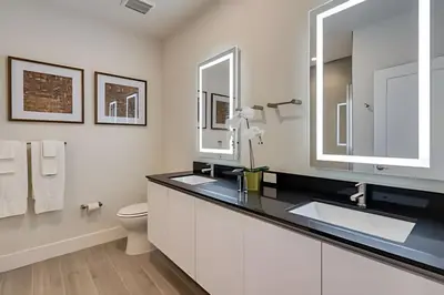 a bathroom with a sink and a toilet and a mirror at Casa 4Q Hidden Forest c/ Piscina in Orlando