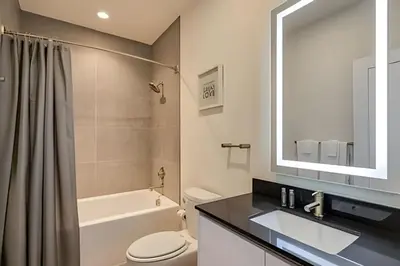 a bathroom with a sink and a toilet and a mirror at Casa 4Q Hidden Forest c/ Piscina in Orlando