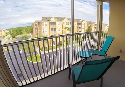 a balcony with two chairs and a view of a street at Condo 3Q Windsor Hills — Perto da Disney in Orlando
