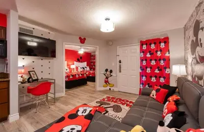 a living room with a couch and a childs bedroom at Mickey's Hideaway Condo Near Disney in Orlando