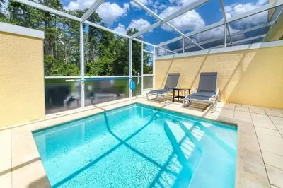 a swimming pool with two chairs and a large window at Casa 3Q Serenity c/ Piscina – Perto da Disney in Orlando