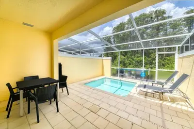 a house with a pool and a table and chairs at Casa 3Q Serenity c/ Piscina – Perto da Disney in Orlando