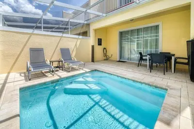 a swimming pool with chairs and a table and a house at Casa 3Q Serenity c/ Piscina – Perto da Disney in Orlando