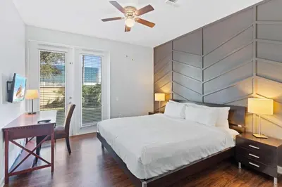 a bedroom with a bed and a desk and a ceiling fan at Amplo Townhouse 3 Quartos no Vista Cay Resort in Orlando