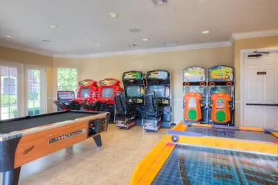 a room with a pool table and a bunch of arcade machines at Condo 3Q Vista Cay c/ Varanda e Piscina Resort in Orlando