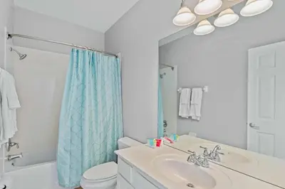 a bathroom with a sink and a toilet and a mirror at Townhouse Moderno 3 Quartos no Vista Cay Resort in Orlando
