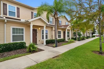 a house with palm trees and a sidewalk at Casa 3Q Moderna perto da Disney e acesso ao Resort in Kissimmee