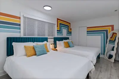 two beds in a room with colorful walls at Kissimmee Retreat with Jacuzzi and Games in Kissimmee