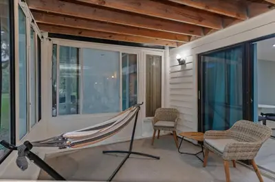 a porch with a hammock and two chairs and a table at Kissimmee Retreat with Jacuzzi and Games in Kissimmee