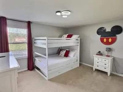 a childs bedroom with a bunk bed with an apple on the wall at Refúgio c/ Vista do Lago e Piscina – Perto Disney in Kissimmee