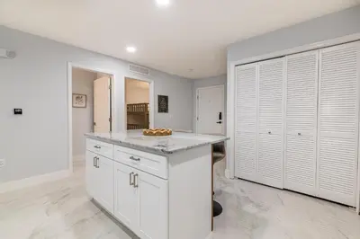a kitchen with white cabinets and a counter top at Family-Friendly Apartment Near Disney & Universal in Kissimmee