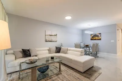 a living room with a white couch and a table at Family-Friendly Apartment Near Disney & Universal in Kissimmee