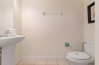 a white bathroom with a toilet and a sink at Conforto e Diversão no Bella Vida – 3Q+ Piscina in Kissimmee