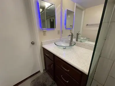 a bathroom with a glass sink and a mirror at Residence near trails, shopping in Orlando