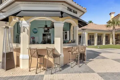 a building with a bar with chairs in front of it at Family-Friendly 3-Bedroom Condo for 6 and 5 min to Disney in Orlando