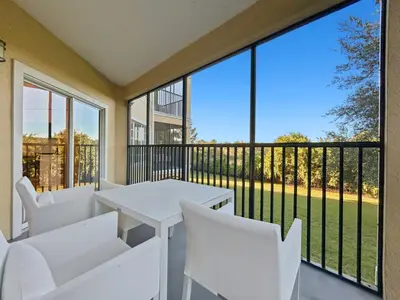 a balcony with a white table and white chairs at Family-Friendly 3-Bedroom Condo for 6 and 5 min to Disney in Orlando
