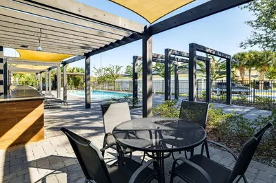 a patio with a table and chairs and a pool at 4 Mi to Disney! Pet-Friendly Home with Pool Access in Kissimmee