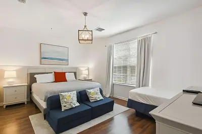 a bedroom with a bed and a blue couch at Apartamento Vista Cay: ao lado do UNIVERSAL in Orlando