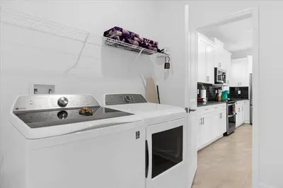 a kitchen with white cabinets and a stove top oven at Disney Escape Villa Pool Resort Amenities in Kissimmee