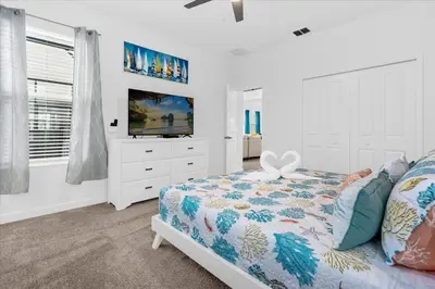 a white bedroom with a bed and a television at Disney Escape Villa Pool Resort Amenities in Kissimmee