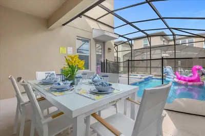 a dining room with a table and a swimming pool at Disney Escape Villa Pool Resort Amenities in Kissimmee