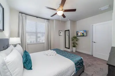 a bedroom with a bed and a ceiling fan at Disney Escape 3BR Home Pool in Orlando
