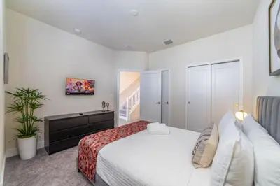 a bedroom with a large bed and a tv at Disney Escape 3BR Home Pool in Orlando