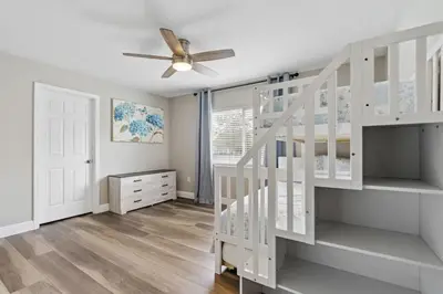 a white staircase in a room with a ceiling fan at Cozy Pool Villa Minutes Drive to Disney in Orlando