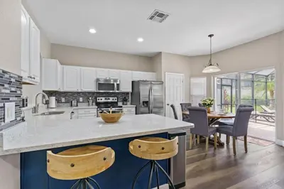 a kitchen and dining room with a table and chairs at Cozy Pool Villa Minutes Drive to Disney in Orlando