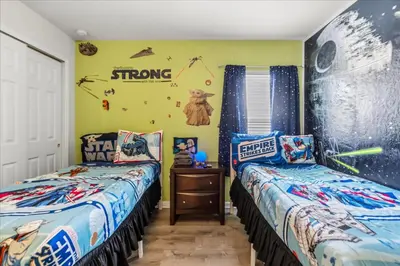 a bedroom with two beds and a wall with stars and planets at Large Family Retreat Pool BBQ Disney Parks Nearby in Orlando