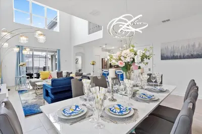 a dining room and living room with a table and chairs at Bright Pool Villa Gated Resort Disney Shuttle Nearby in Kissimmee