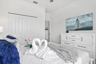 a bedroom with two swans shaped towels on a bed at Bright Pool Villa Gated Resort Disney Shuttle Nearby in Kissimmee