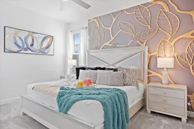 a bedroom with a white bed with a colorful wall at Bright Pool Villa Gated Resort Disney Shuttle Nearby in Kissimmee