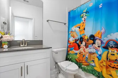 a bathroom with a toilet and a shower curtain at Bright Pool Villa Gated Resort Disney Shuttle Nearby in Kissimmee
