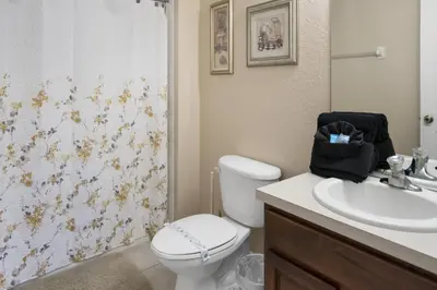 a bathroom with a toilet and a sink at Bright Resort Home Pool Near Disney in Orlando