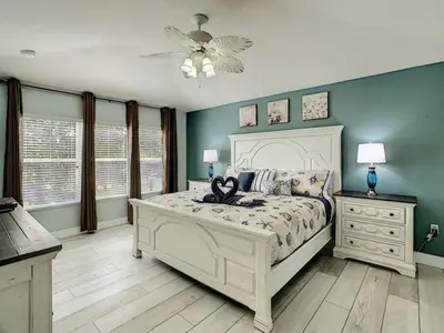 a bedroom with a white bed and blue walls at Modern 6BR Resort Private Pool Near Disney in Orlando