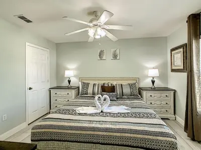 a bedroom with a bed with a ceiling fan at Modern 6BR Resort Private Pool Near Disney in Orlando