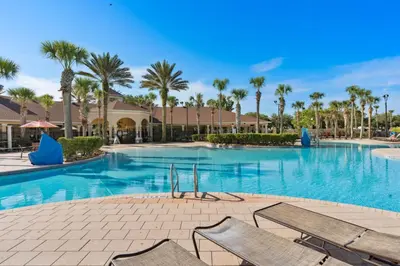 a large swimming pool with chairs and palm trees at Modern 6BR Resort Private Pool Near Disney in Orlando