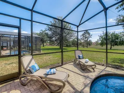 two chairs and a swimming pool in a glass house at Modern 6BR Resort Private Pool Near Disney in Orlando