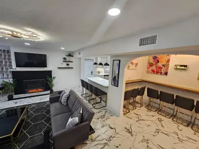 a living room with a couch and a bar at Stylish Duplex walkTO Lake Eola Orlando. Sleeps 8 in Orlando