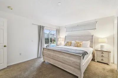 a bedroom with a large bed and a window at Casa c/ Piscina Privativa e Game Room in Kissimmee