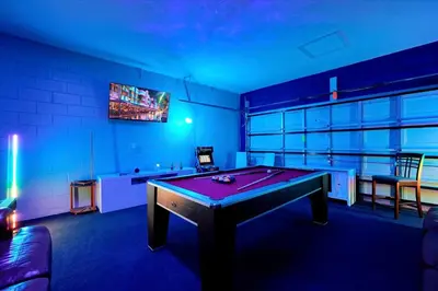 a ping pong table in a room with blue lighting at Family-Friendly 6-Bedroom Villa with Pool Game Room and Themed Bedrooms at Emerald Island Resort in Kissimmee