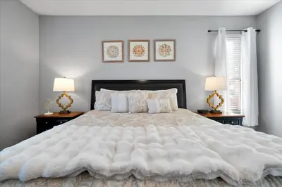 a bedroom with a large white bed with two lamps at Family-Friendly 6-Bedroom Villa with Pool Game Room and Themed Bedrooms at Emerald Island Resort in Kissimmee