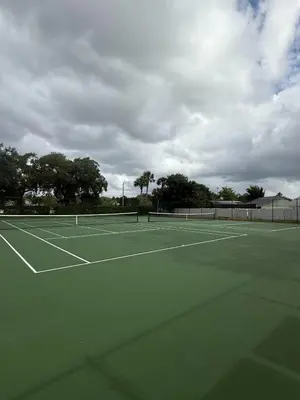 a tennis court with two tennis rackets on it at Sunny Orlando Oasis - Cozy 2 Bedroom house near Disney in Kissimmee