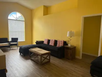 a living room with a couch and a table at Sunny Orlando Oasis - Cozy 2 Bedroom house near Disney in Kissimmee